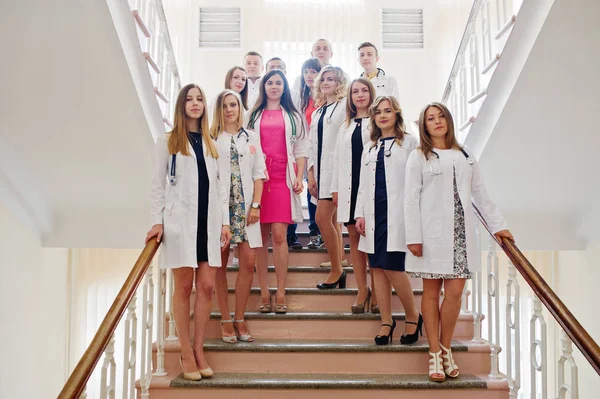 Gruppo di giovani medici in camice bianco in posa in ospedale . — Foto Stock