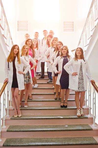 Gruppo di giovani medici in camice bianco in posa in ospedale . — Foto Stock