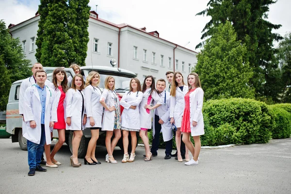 Cool jeunes médecins ou travailleurs médicaux posant à l'extérieur de l'hôpital — Photo