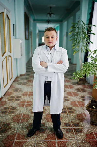 Guapo y seguro de sí mismo joven médico de bata blanca con estetosco — Foto de Stock