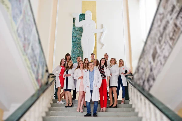 Genç doktor hastanede poz beyaz kat olarak grup.