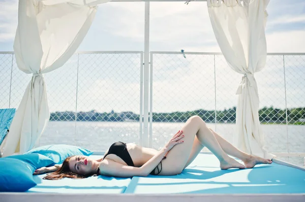 Retrato de una hermosa chica en traje de baño de bikini negro acostado — Foto de Stock