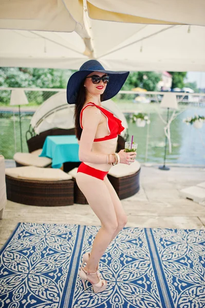Korku veren genç kadın kırmızı bikini bir mojito kokteyl ile poz 