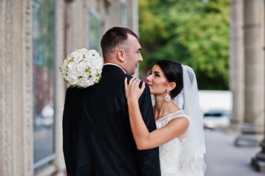 İki muhteşem düğün yürüyor ve yanında sütun o poz