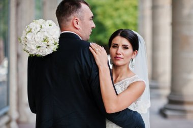 İki muhteşem düğün yürüyor ve yanında sütun o poz