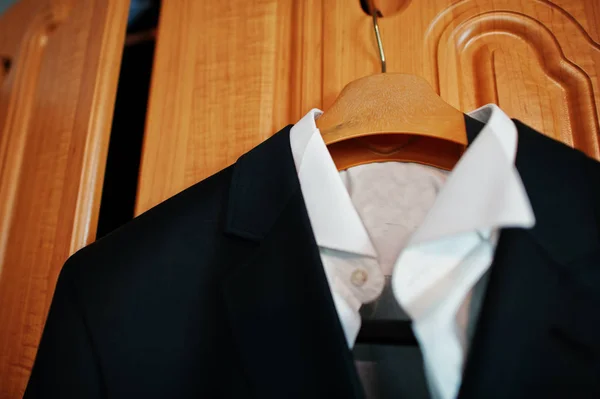 Chaqueta de novia negro del novio y camisa blanca colgando en el estante —  Fotos de Stock