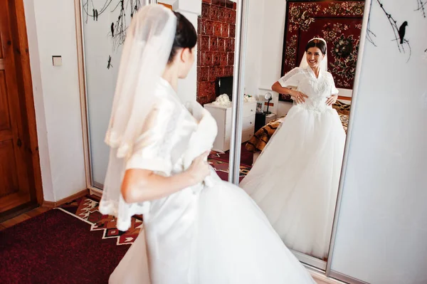 Θαυμάσιο νύφη κρατώντας το εκλεπτυσμένο λευκό γάμο φόρεμα. — Φωτογραφία Αρχείου