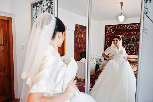 Fabulosa noiva segurando seu vestido de noiva branco sofisticado . — Fotografia de Stock