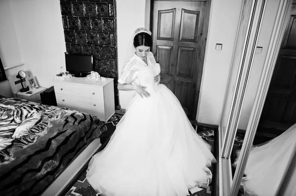 Favolosa sposa tenendo il suo sofisticato abito da sposa bianco. Bl — Foto Stock