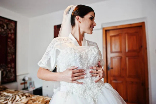 Fabulosa noiva segurando seu vestido de noiva branco sofisticado . — Fotografia de Stock