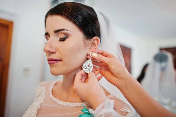Допомагає нареченої нареченої покласти на її весілля розкішний сережки. — стокове фото