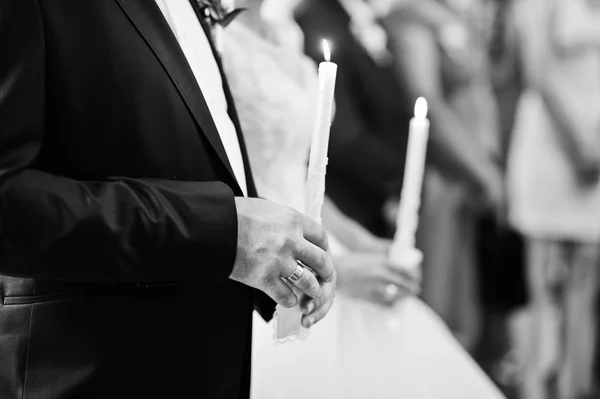 Świeżo poślubiona para trzymając świece w kościele na ich ślubne — Zdjęcie stockowe