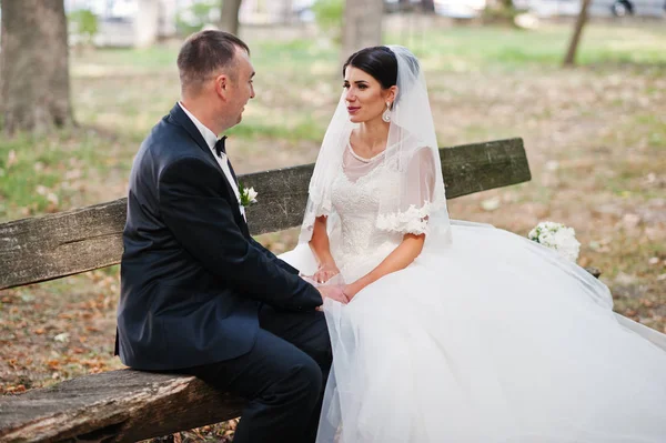 梦幻般的婚礼夫妇坐在公园的长凳上，在 — 图库照片