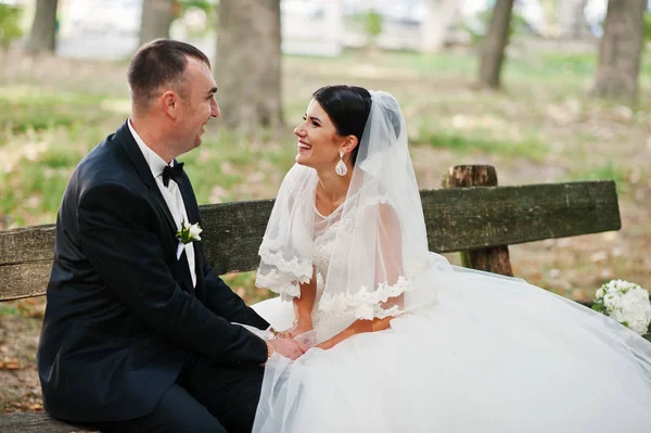 Fantastiska bröllop par sitta på bänken i parken den — Stockfoto