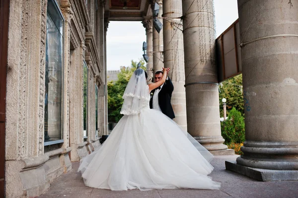 Fabelhaftes Hochzeitspaar geht und posiert neben den Säulen o — Stockfoto