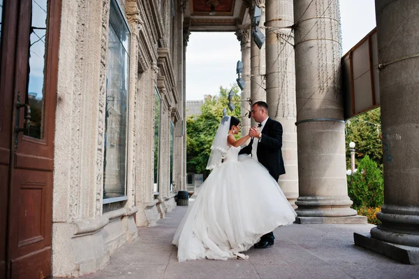 İki muhteşem düğün yürüyor ve yanında sütun o poz