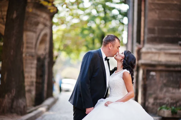 Impresionante joven pareja de boda besándose en la calle de la vieja t — Foto de Stock