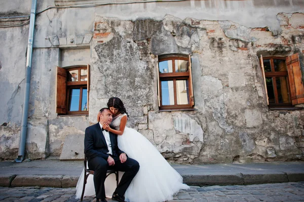 Bonito noivo sentado na cadeira com um belo suporte de noiva — Fotografia de Stock