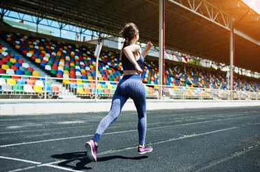 Spor giyim stadi içinde çalışan güçlü bir uygun kız portresi