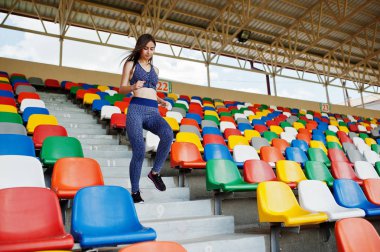 Stadyumda merdiven üzerinde çalışan aktif genç kadın.