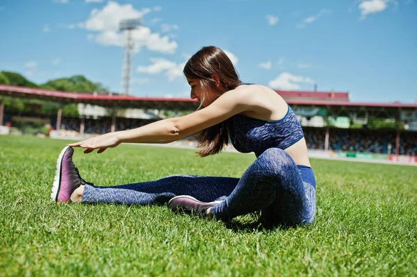 Retrato de una hermosa mujer en ropa deportiva estirando su muscl — Foto de Stock