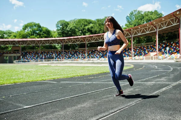 Retrato de una chica fuerte en forma en ropa deportiva corriendo en el stadi — Foto de Stock