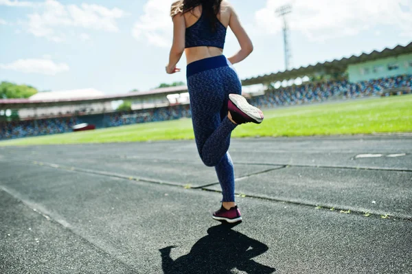 Portrait of a strong fit girl in sportswear running in the stadi — Stock Photo, Image