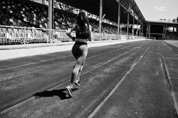 Портрет сильной девушки в спортивной одежде, бегущей по стадиону — стоковое фото