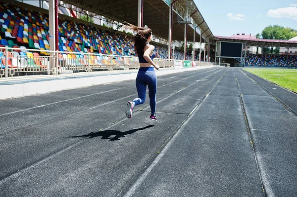 Retrato de uma garota forte em sportswear correndo no stadi — Fotografia de Stock