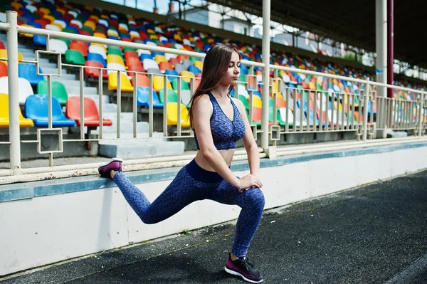 Portrait of a gorgeous girl doing squats in the stadium. — Stock Photo, Image