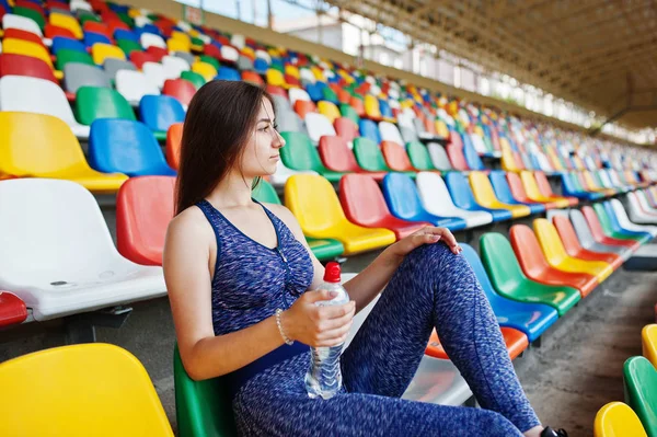 Retrato de uma mulher bonita em sportswear sentado e bebendo wa — Fotografia de Stock
