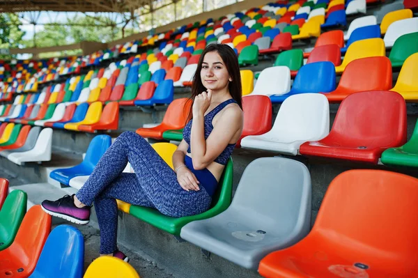 Linda jovem mulher em forma sentada em uma cadeira no estádio . — Fotografia de Stock