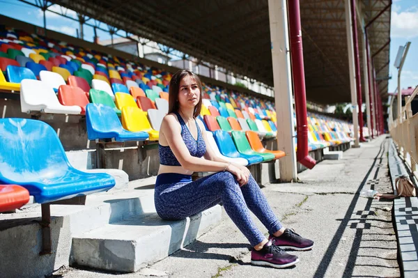 Preciosa mujer joven en forma sentada en una silla en el estadio . — Foto de Stock