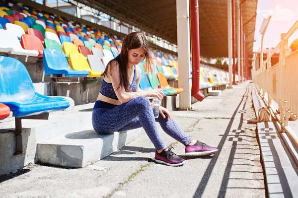 Muhteşem genç stadyumun bir sandalyesi üzerinde oturan kadın yerleştirmek.