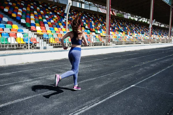 Spor giyim stadi içinde çalışan güçlü bir uygun kız portresi