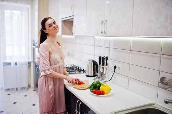 Portrait of an attractive young woman in robe making salad out o — Stock Photo, Image