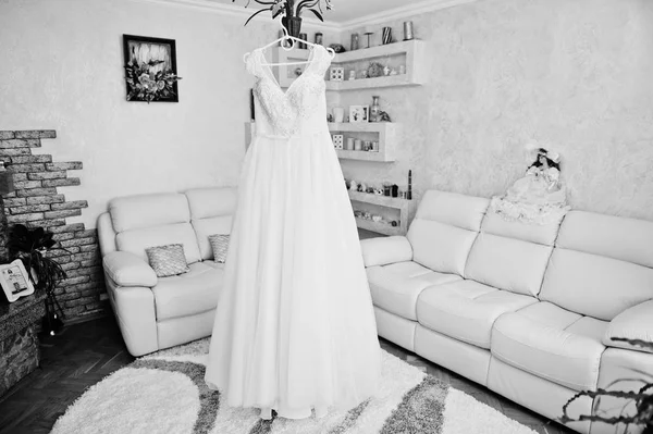 シャンデリア上のラックに掛かっている素敵な白いウェディング ドレス — ストック写真