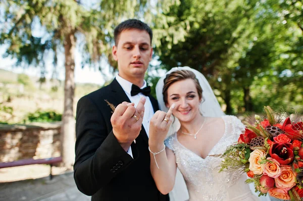 Happy bride and groom showing their ring fingers with wedding ri — Stock Photo, Image