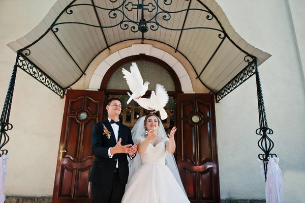 Awesome wedding couple releasing doves into the sky. — Stock Photo, Image