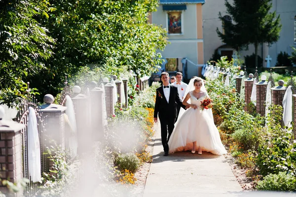 Fantastiska bröllop par gå ur kyrkan. — Stockfoto