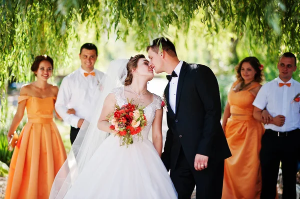 Schönes Hochzeitspaar spazieren geht und Spaß mit Trauzeugen hat — Stockfoto