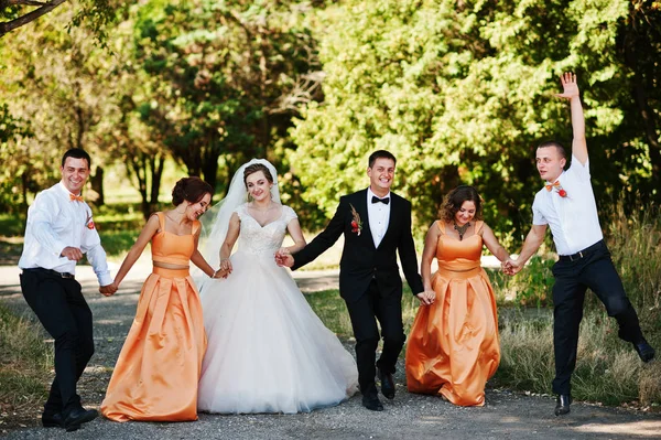 Mooie bruidspaar wandelen en plezier maken met groomsmen een — Stockfoto