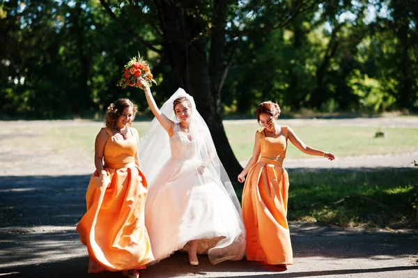Noiva feliz se divertindo com suas damas de honra divertidas no parque — Fotografia de Stock