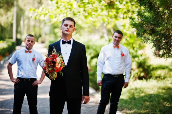 Knappe bruidegom lopen met zijn bestmen of de groomsmen in het park — Stockfoto