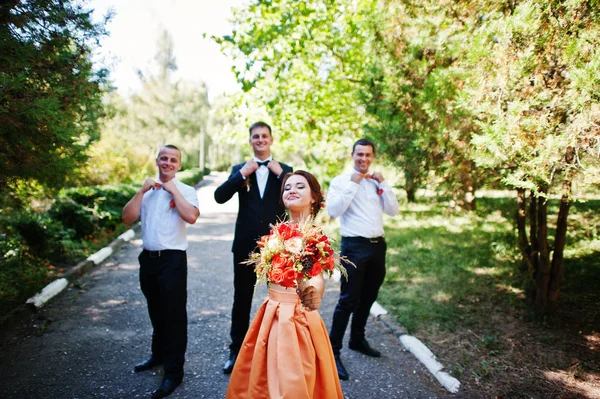 Novio guapo caminando con sus padrinos y una dama de honor en th — Foto de Stock