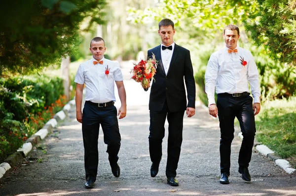 Yakışıklı damat ile onun bestmen ya da groomsmen parkta yürüyüş