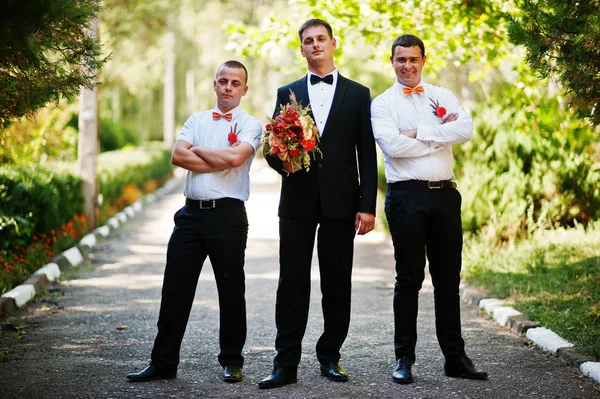 Novio guapo caminando con sus mejores hombres o padrinos en el parque —  Fotos de Stock