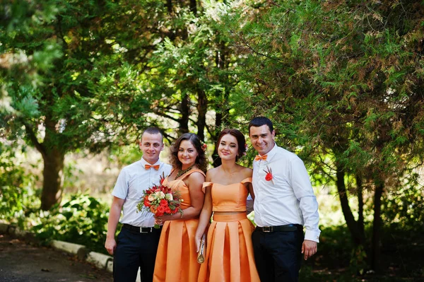 Schöne Brautjungfern mit hübschen Trauzeugen im Park. — Stockfoto