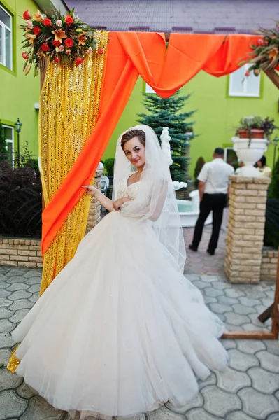 Flawless young bride in gorgeous white wedding gown posing next — Stock Photo, Image