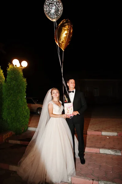 Fantástica pareja de bodas; perder con globos en la noche al aire libre . —  Fotos de Stock